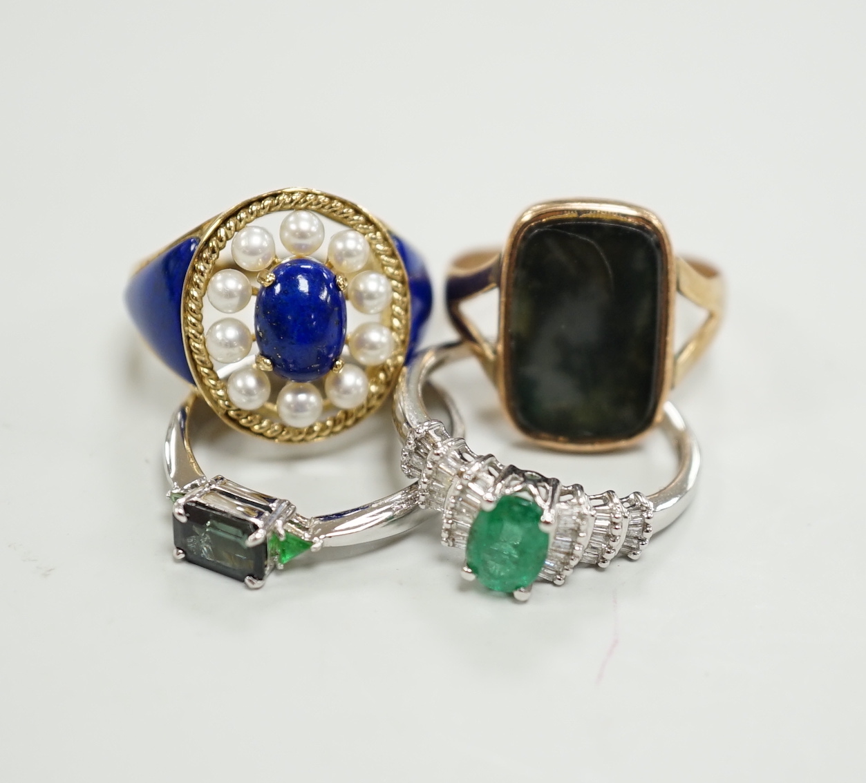 A modern 750 white metal and three stone gem set ring, two 9ct gold and gem set rings including lapis and seed pearl and one other yellow metal ring.